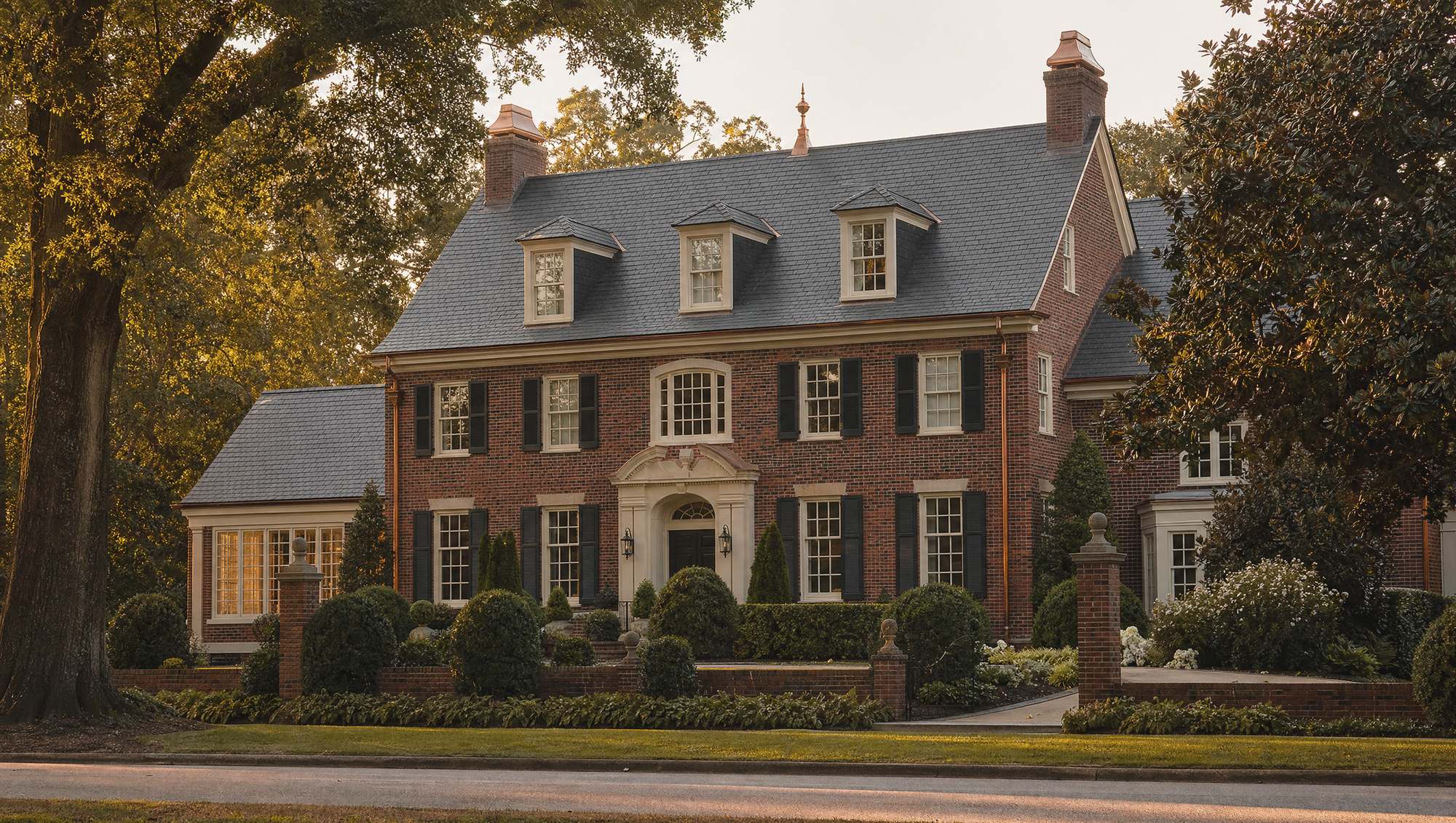 Slate roof on a traditional brick home with dormer windows and copper details